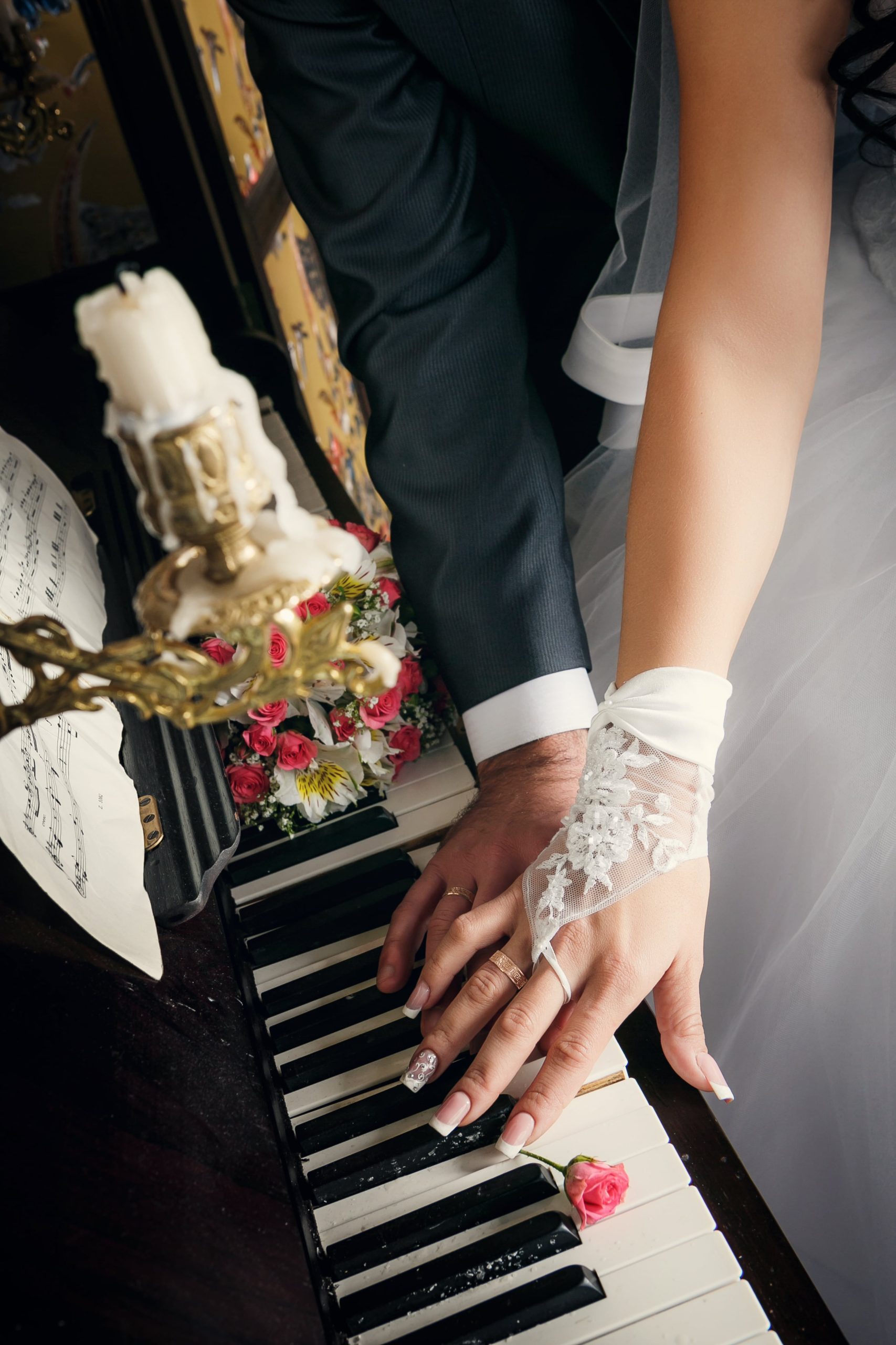 Hochzeitspaar am Klavier halten Händchen
